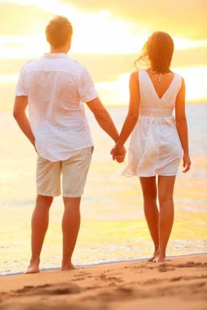 Man and woman on the beach holding hands